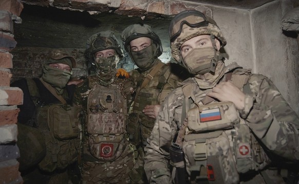 In this photo released by the Russian Defense Ministry Press Service on Tuesday, June 25, 2024, Russian soldiers pose for photo in a shelter at their position in an undisclosed location in Ukraine. (R ...
