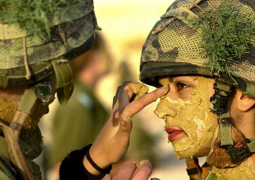 ** PICTURE MADE AVAILABLE MAY 23, 2005 ** In this picture released by the Israeli Defense Force, a female Israeli soldier training to be an infantry instructor has mud used for camouflage applied to h ...