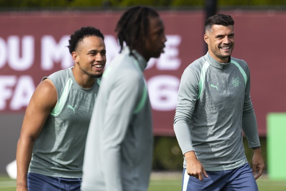 epa13079338 Switzerland's Granit Xhaka (R) and his teammates Noah Okafor (L) and Johan Manzambi during a training session one day ahead of the FIFA World Cup round of 32 match between Switzerland ...