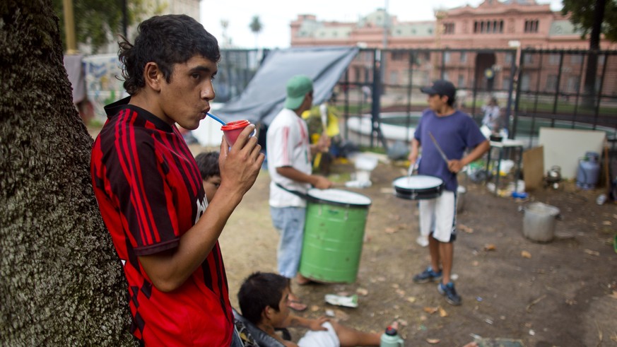 Unemployed youth who belong to a nationwide organization of unemployed and retired people camp outside the Casa Rosada government palace, background, to protest government policies that they believe e ...