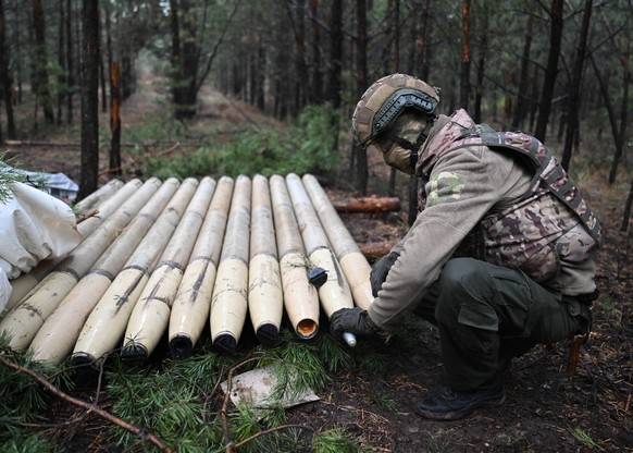 Russia Ukraine Military Operation Artillery Unit 8544288 27.10.2023 A Russian serviceman of the Central Military District handles ammunition of a BM-21 Grad multiple rocket launcher in the course of R ...