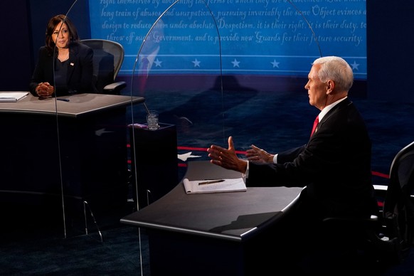 epa08728329 Democratic vice presidential candidate Sen. Kamala Harris (L), D-Calif., listens as Vice President Mike Pence (R) answers a question during the vice presidential debate the vice presidenti ...