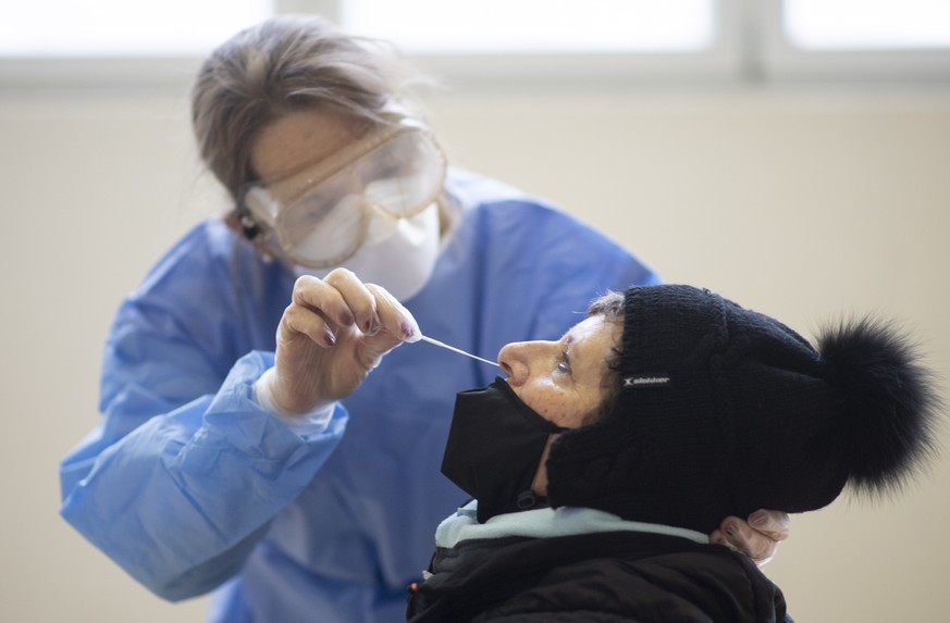 epa08876668 Medical staff takes a Covid-19 quick test during Covid-19 mass testing, in Zuoz, Switzerland, 11 December 2020. Three regions in the canton of Grisons will be mass tested during three days ...