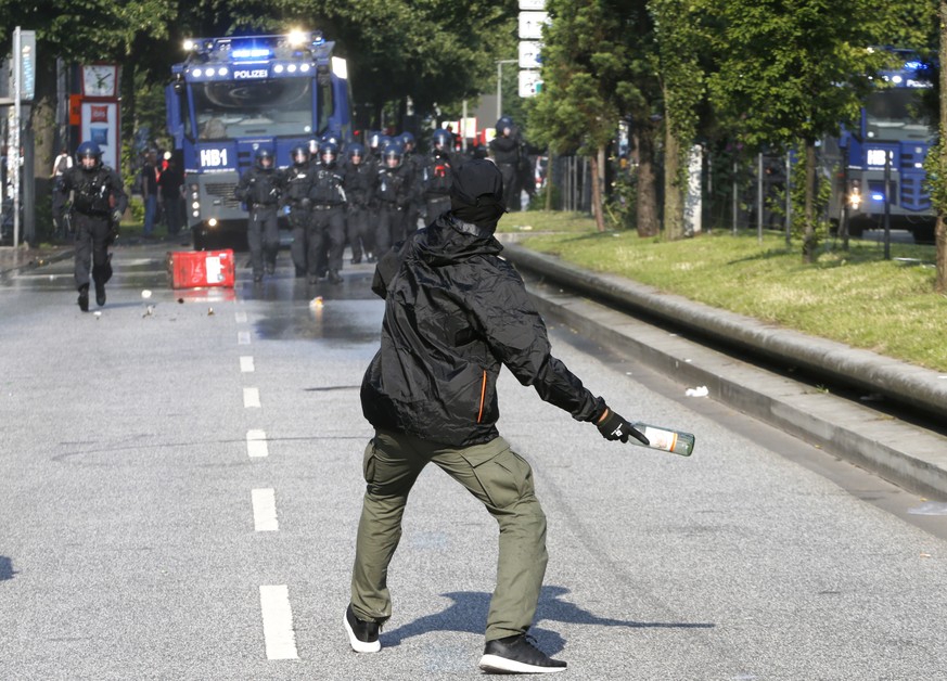 A demonstrator throws a bottle towards police on the first day of the G-20 summit in Hamburg, northern Germany, Friday, July 7, 2017. The leaders of the group of 20 meet July 7 and 8. (AP Photo/Michae ...