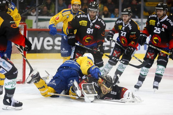 Davos&#039; Andres Ambuehl liegt auf Berns Torhueter Leonardo Genoni, im Eishockey Meisterschaftsspiel der National League zwischen dem SC Bern und dem HC Davos, am Samstag, 1. Dezember 2018, in der P ...