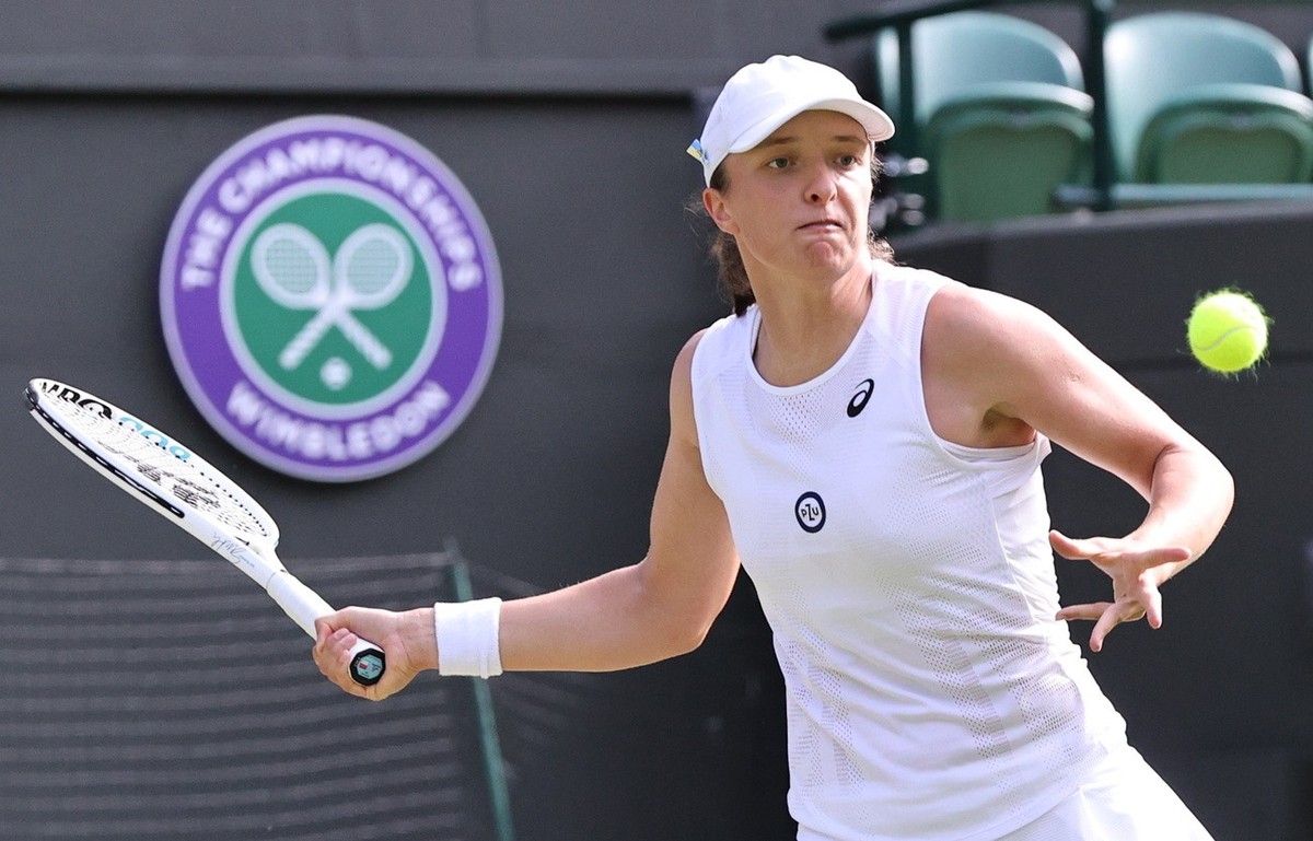 epa10048102 Iga Swiatek of Poland in action against Alize Cornet of France during their Women's third round match at the Wimbledon Championships, in Wimbledon, Britain, 02 July 2022. EPA/KIERAN G ...