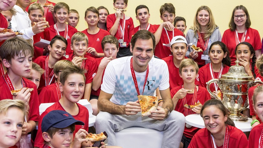 epa06297283 Switzerland&#039;s Roger Federer (C) eats pizza with ball kids after defeating Argentina&#039;s Juan Martin del Potro in their final match of the Swiss Indoors tennis tournament at the St. ...