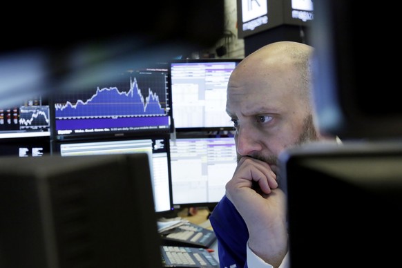 Trader Meric Greenbaum is framed by his monitors as he works on the floor of the New York Stock Exchange, Thursday, March 22, 2018. Stocks plunged, sending the Dow Jones industrials down more than 700 ...