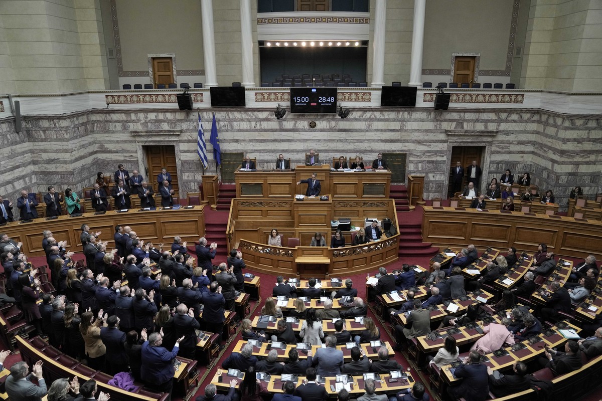 Lawmakers of the New Democracy ruling party applaud Greek Prime Minister Kyriakos Mitsotakis during his speech in parliament ahead of the submission of a no-confidence motion by opposition parties ove ...