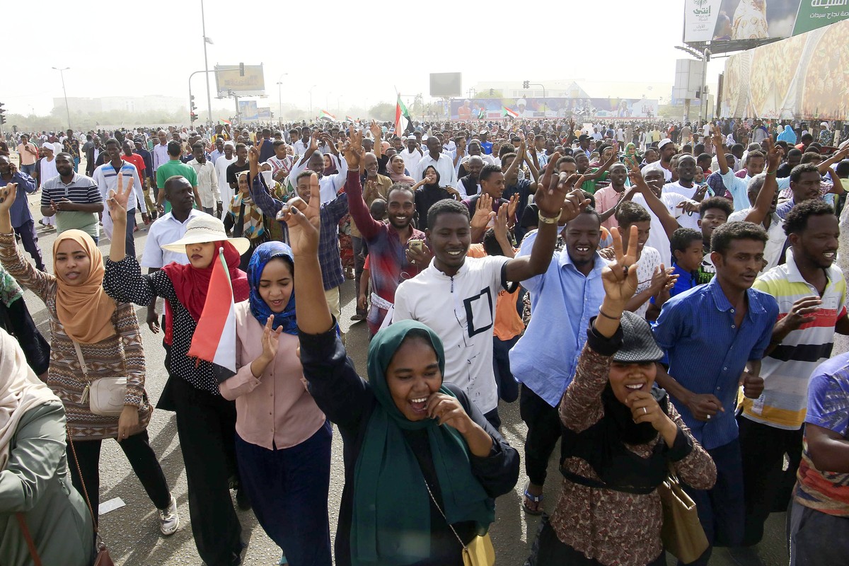 epa07498331 Sudanese people celebrate as they head towards the Army headquarters amid rumors that President Omar al-Bashir has stepped down, in Khartoum, Sudan, 11 April 2019. According to media repor ...