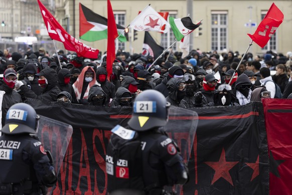 Protestors hold "Smash WEF" banners while members of the police watch the demonstration against the World Economic Forum WEF in Bern, Switzerland, Saturday, January 17, 2026. (KEYSTONE/Peter ...
