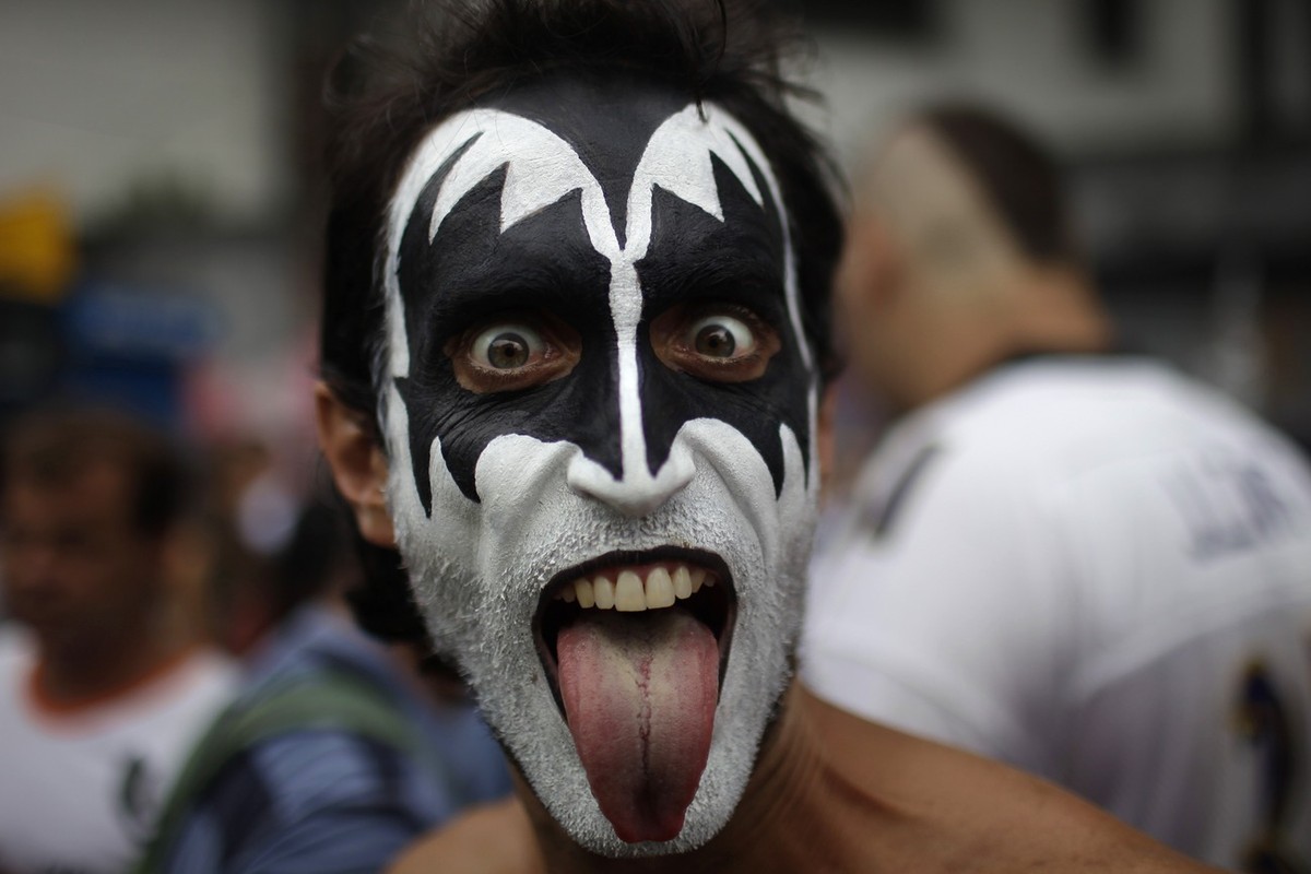 A reveler, with his face painted as musical group Kiss member Gene Simons, sticks his tongue out during the "Carmelitas" street carnival parade in Rio de Janeiro, Brazil, Friday, March 4, 20 ...