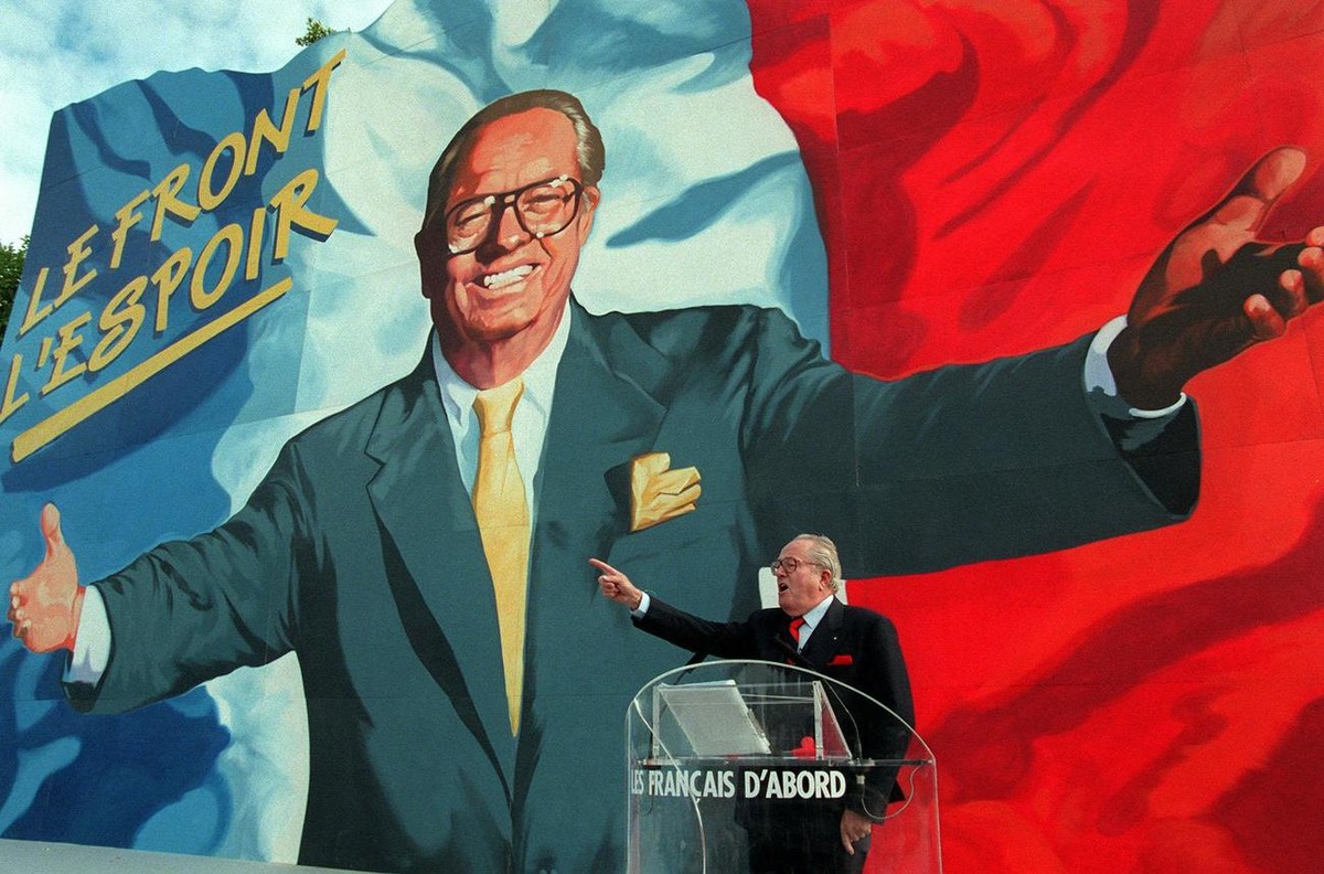 Jean-Marie Le Pen, leader of the far-right National Front party, is dwarfed by a giant image of himself as he addresses his followers at the end of the two-day Blue-White-Red meeting, the party's ...