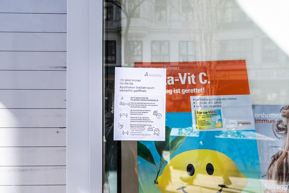 epa08295958 A warning sign reading 'Wir sind immer für Sie da. Apotheken bleiben auch weiterhin geoeffnet.' (lit.: We are always here for you. Pharmacies will remain open.) is seen on a pharmacy windo ...