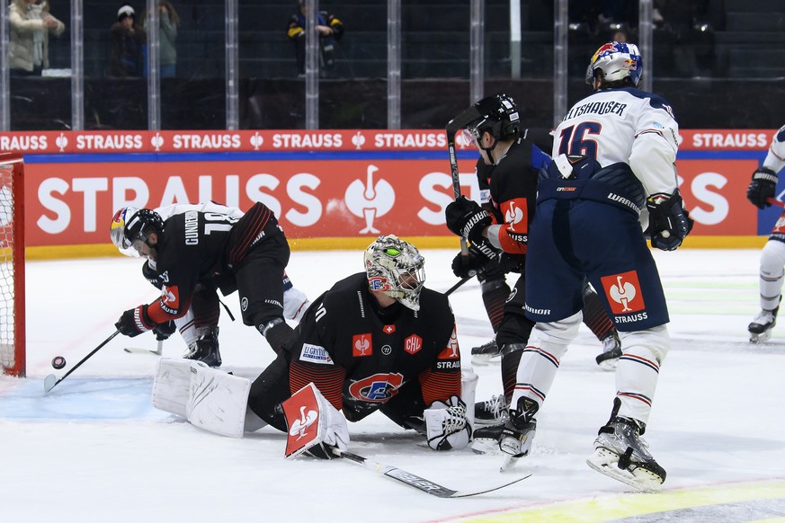 Muenchen&#039;s Konrad Abeltshauser, right, scores a goal against Fribourg&#039;s goaltender Reto Berra, center, during the Champions Hockey League match between Switzerland&#039;s HC Fribourg-Gottero ...