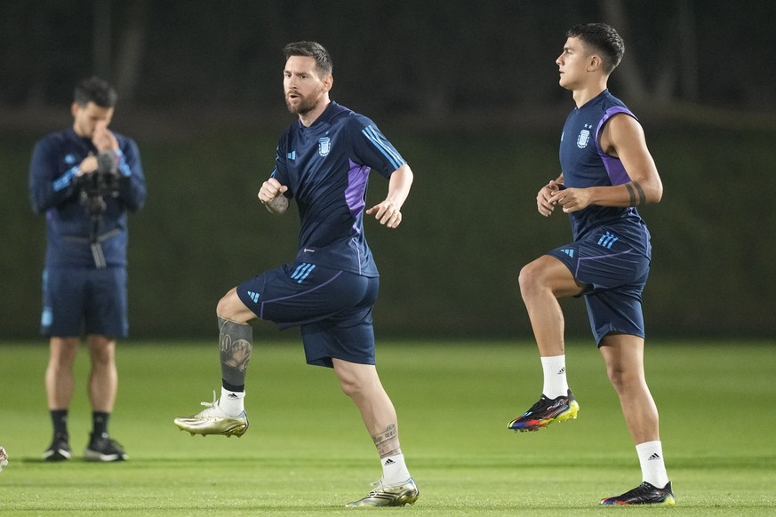 Lionel Messi and Paulo Dybala, right, warm up during a training of Argentina on the eve of a group C World Cup soccer match against Poland in Doha, Qatar, Tuesday, Nov. 29, 2022. (AP Photo/Jorge Saenz ...