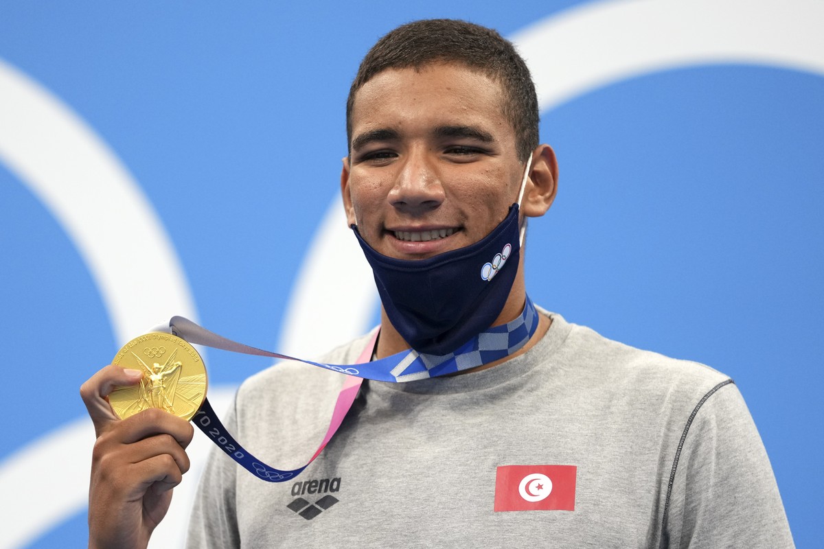 Ahmed Hafnaoui, of Tunisia, poses with his gold medal after winning final of the men's 400-meter freestyle at the 2020 Summer Olympics, Sunday, July 25, 2021, in Tokyo, Japan. (AP Photo/Matthias  ...