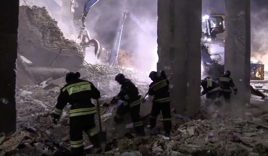 This image made from video and provided by the Russian Emergency Situations Ministry shows Emergency Situations employees working at the scene of a collapsed section of an apartment building, in Magni ...