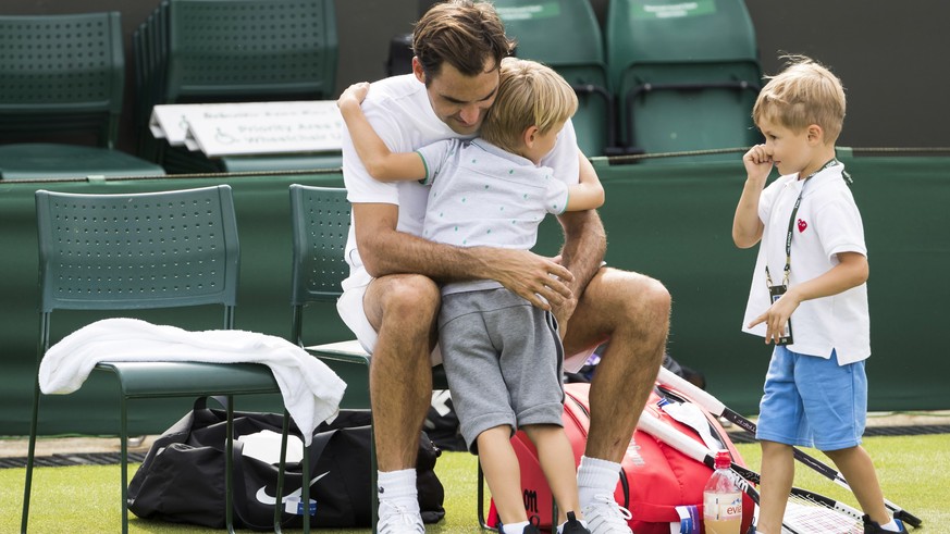 epa06847963 Roger Federer of Switzerland hugs his twin boys Leo and Lenny at the end of a training session at the All England Lawn Tennis Championships in Wimbledon, London, 28, June 2018. The Wimbled ...