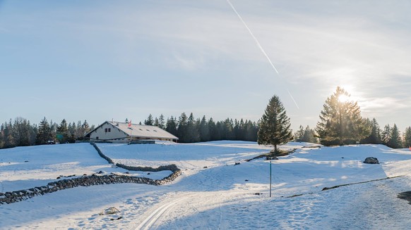 Winter sunlight over Jura landscape in Switzerland Sunlight brightens a snowy winter scene in Jura, Switzerland, casting shadows over the serene landscape. Trees and hills add depth to this tranquil a ...