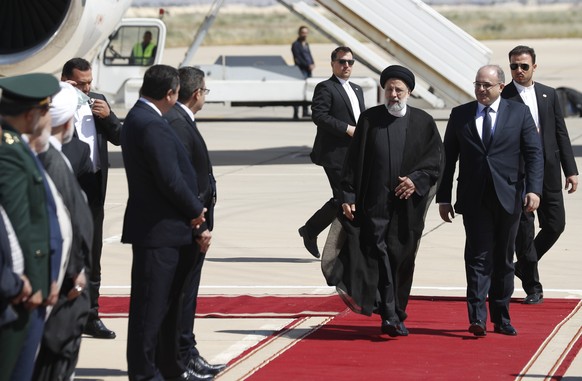 Iranian President Ebrahim Raisi, second right, walks on the red carpet with Syrian Economy Minister Samer al-Khalil upon his arrival to the airport in Damascus, Syria, Wednesday, May 3, 2023. It is th ...