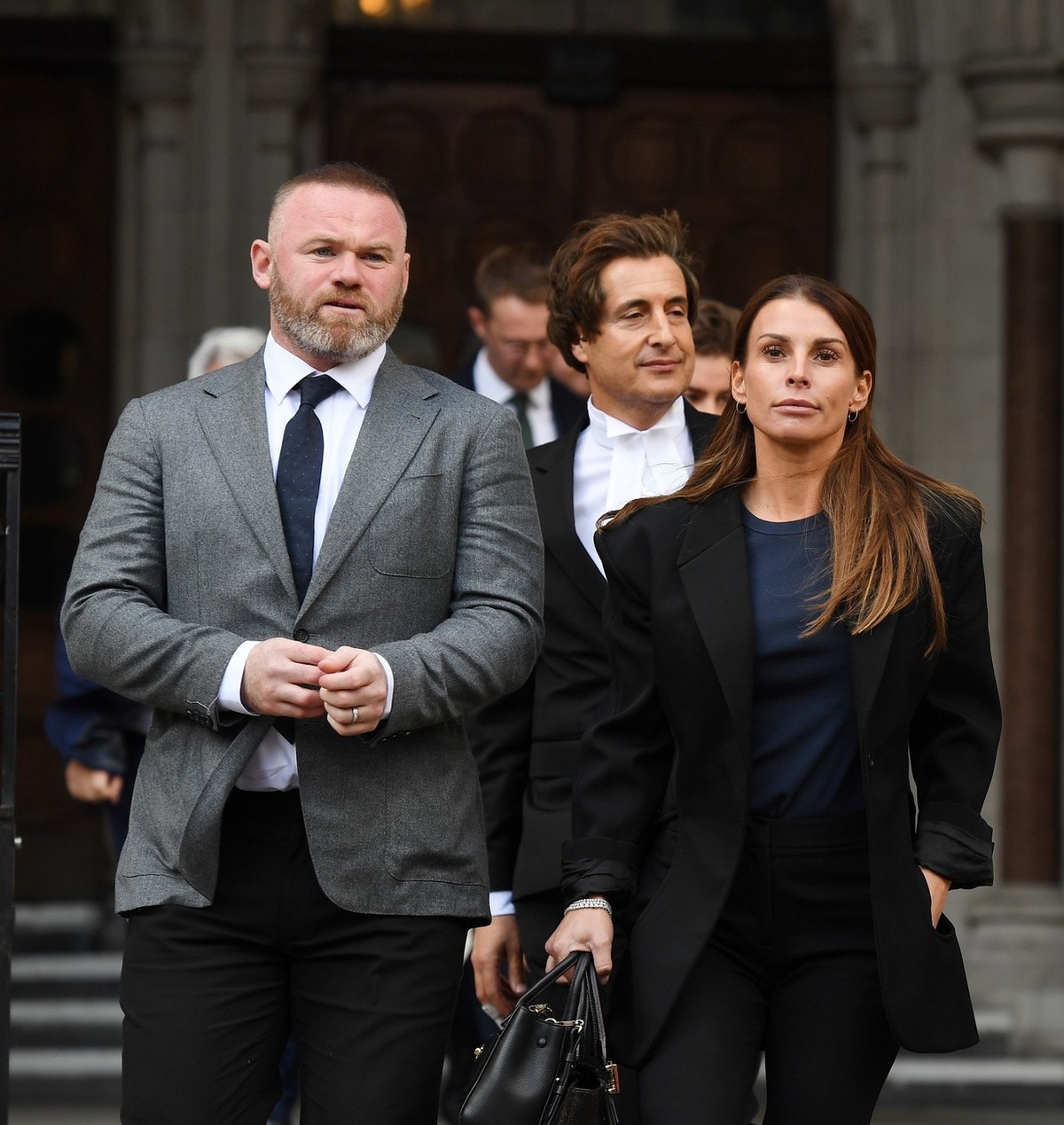 epa09938439 Coleen Rooney (R) departs the High Court with her husband and former England football captain Wayne Rooney (L) in London, Britain, 10 May 2022. Footballers' wives Coleen Rooney and Re ...