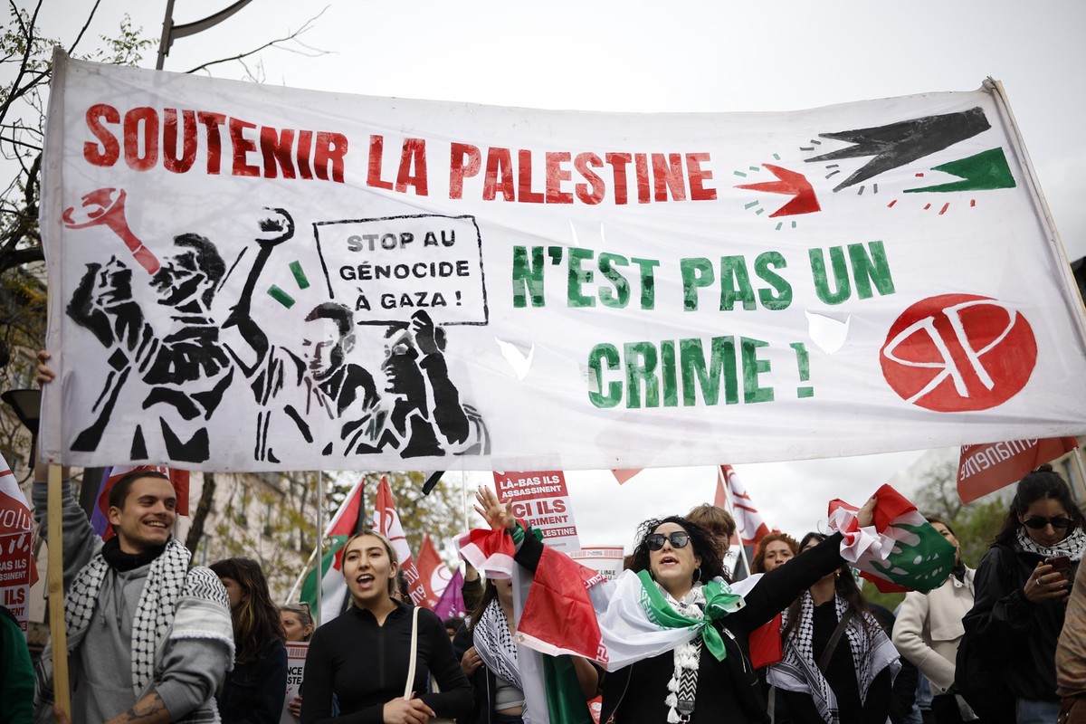 Protesters hold a banner reading "Supporting Palestine is not a crime" and "Stop genocide in Gaza" as they take part in a rally against the Yadan bill, which aims to combat new for ...