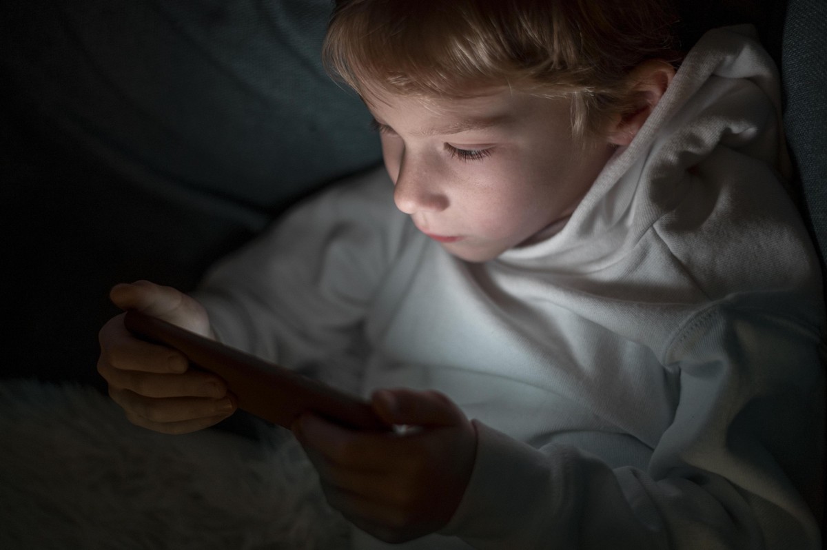 RECORD DATE NOT STATED young boy using smartphone bed 2 *** Jung Junge anhand smartphone Bett +2 IST_35069_65558