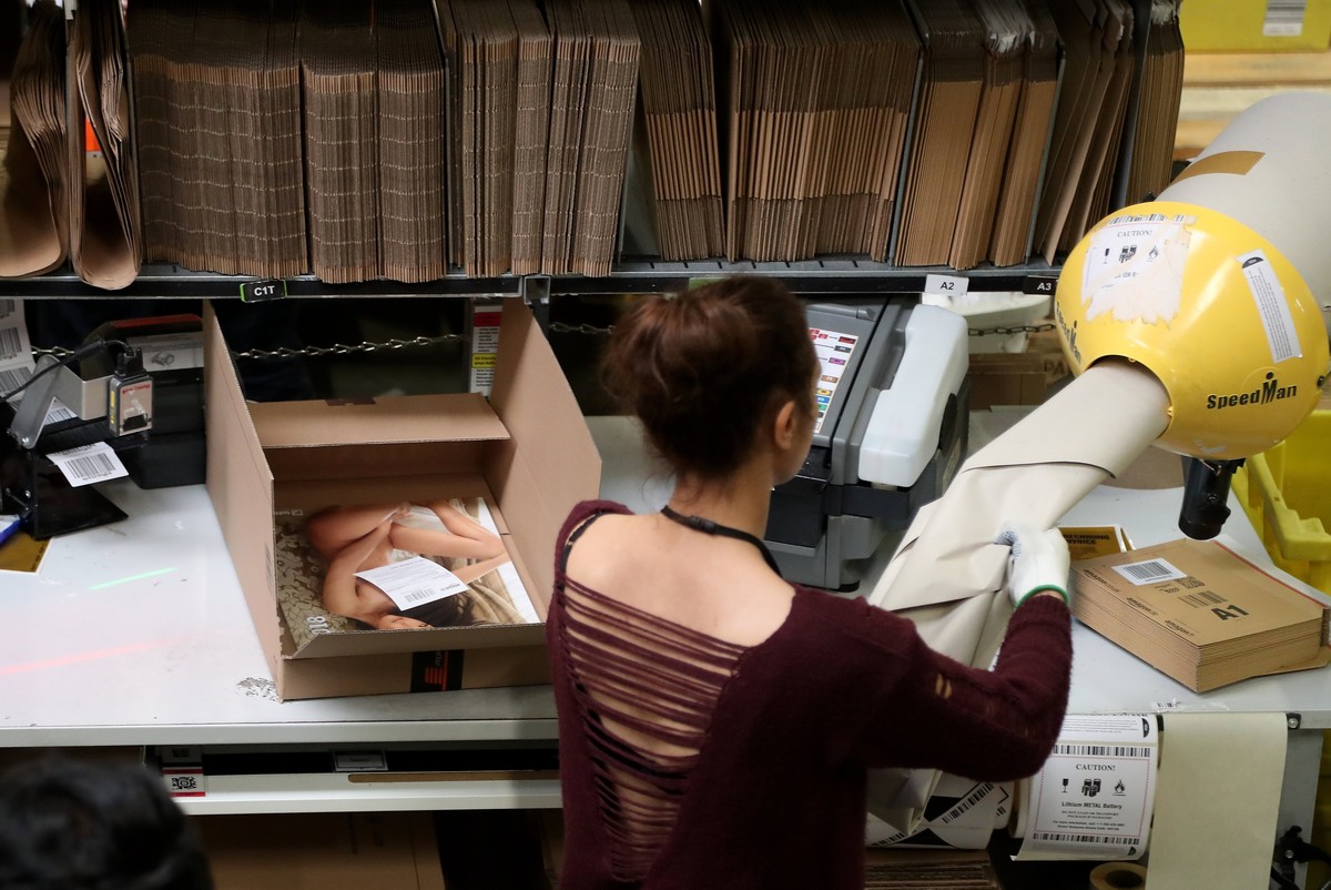 epa06355765 A worker at the Amazon logistics and distribution center in Rheinberg, Germany, 28 November 2017. The Amazon logistics center is directly connected to a 'Deutsche Post' DHL shipp ...