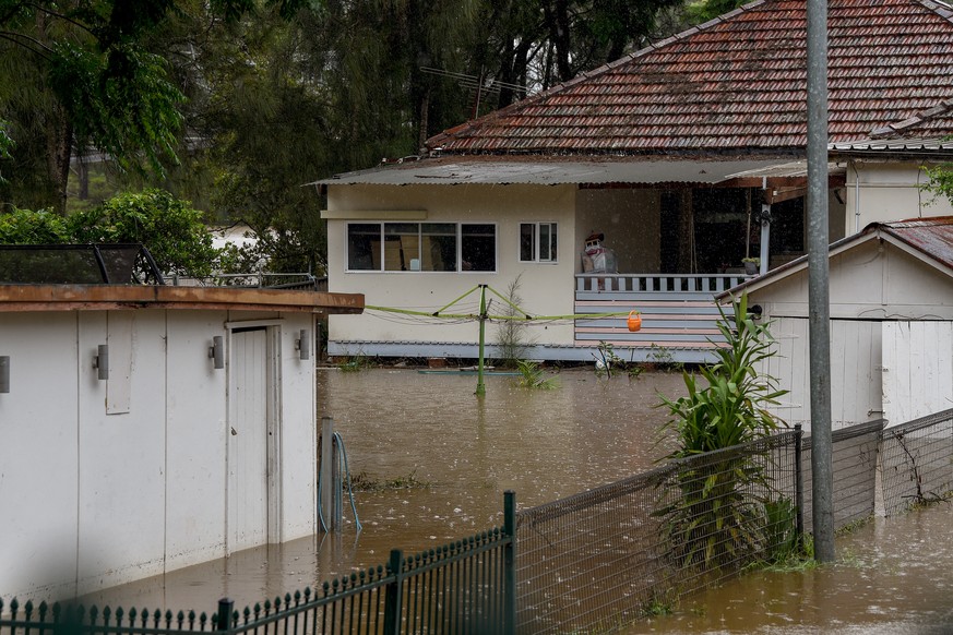 epa09808840 Backyards of properties are submerged under floodwater after the Georges River burst its banks in East Hills, south-west of Sydney, New South Wales, Australia, 08 March 2022. Meteorologist ...