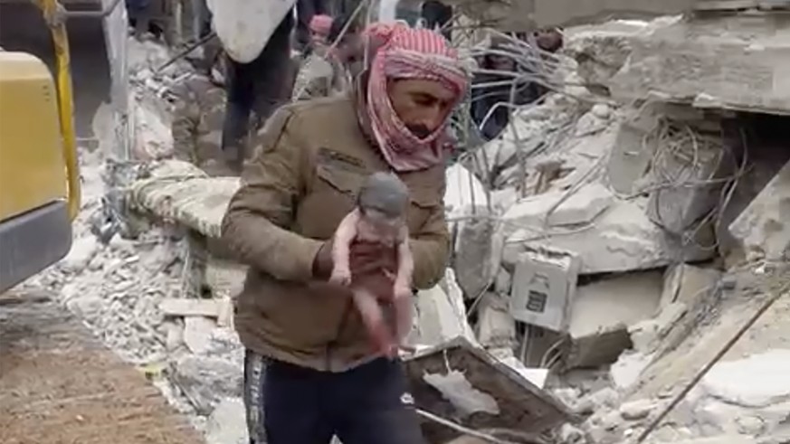 A rescuer carries a baby girl after pulling her from the rubble caused by an earthquake that hit Syria and Turkey in the town of Jinderis, Syria, Tuesday, Feb. 7, 2023. Residents in the northwest Syri ...