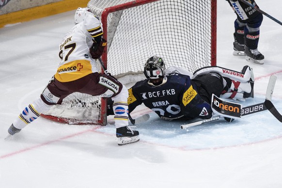 Gotterons Torhueter Reto Berra, rechts, muss gegen Servettes Linus Omark den Treffer zum 1-2 hinnehmen im dritten Eishockey Playoff Viertelfinalspiel der National League zwischen dem HC Fribourg Gotte ...