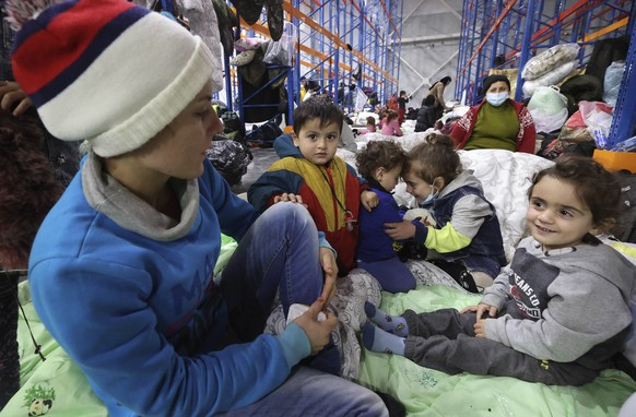 Migrant children settle for the night in the logistics center in the checkpoint &quot;Kuznitsa&quot; at the Belarus-Poland border near Grodno, Belarus, on Wednesday, Nov. 17, 2021. Some of the migrant ...