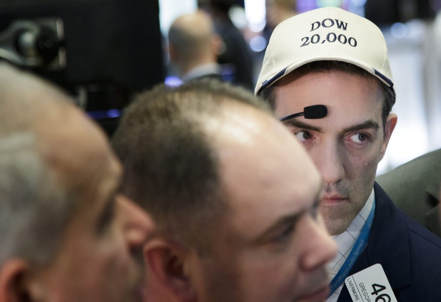 epa05683935 A trader wearing a hat in anticipation of the Dow closing above 20,000 works on the floor of the New York Stock Exchange at the closing bell in New York, New York, USA, on 20 December 2016 ...