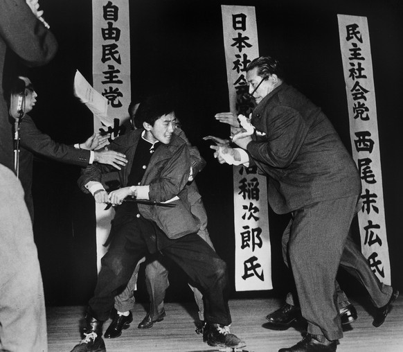 Tokyo Stabbing: The photo was taken directly after Yamaguchi stabbed Asanuma and is here seen attempting a second stab, although he was restrained before that could happen.