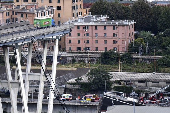 epa06949331 A lorry stationary on a large section of the Morandi viaduct upon which the A10 motorway runs after part of the bridge collapsed in Genoa, Italy, 14 August 2018. At least 22 people are bel ...