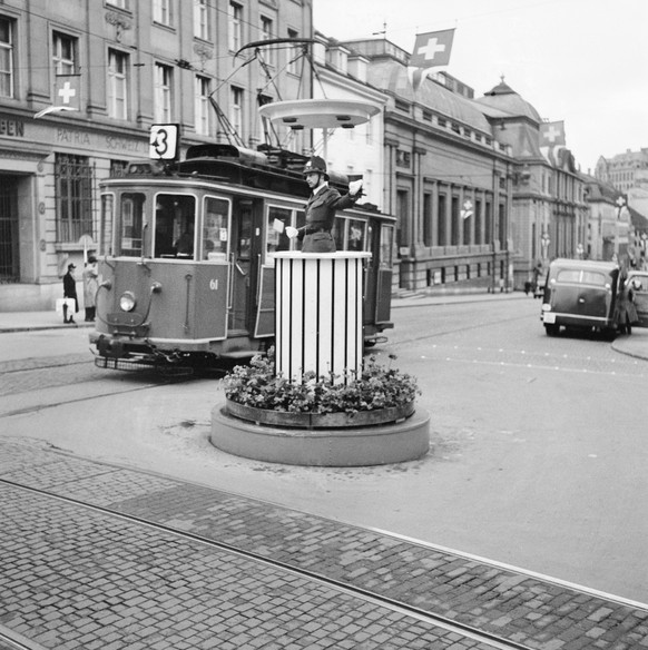 A policeman controls the traffic on the Bankenplatz in Basel, Switzerland, from a traffic pulpit decorated with a geranium bed, on May 6, 1949. (KEYSTONE/PHOTOPRESS-ARCHIV/Str)

Ein Polizist regelt am ...