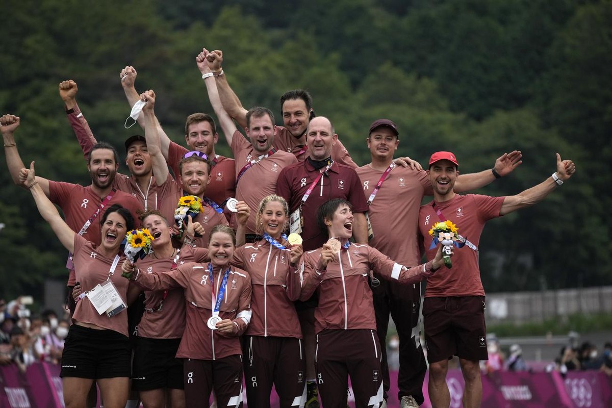 Switzerland's gold medalist Jolanda Neff, center front, silver medalist Sina Frei, left front, and bronze medalist Linda Indergand, right front, pose with their medals and their team during a med ...