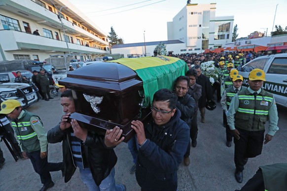 epa08010352 A group of people participates in the wake of policeman Juan Jose Alcon Parra, who died yesterday after he was attacked by a mob, during the looting and burning of the Integral Police Stat ...