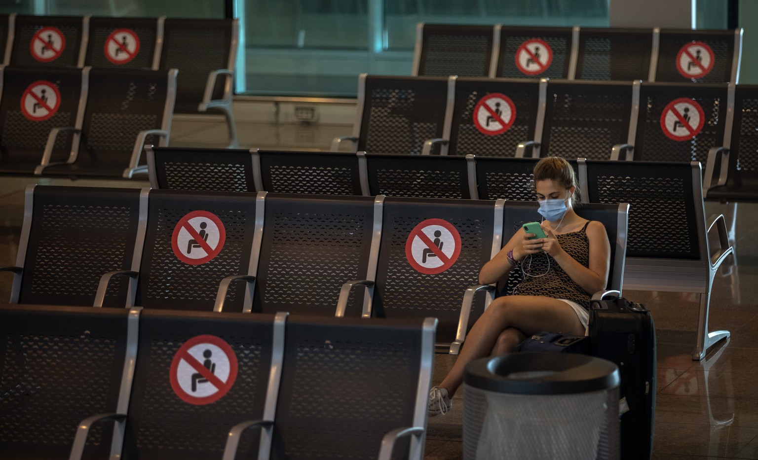 A passenger sits at Barcelona airport in Barcelona, Spain, Tuesday, June 30, 2020. The European Union on Tuesday is announcing a list of nations whose citizens will be allowed to enter 31 European cou ...