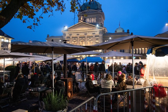 Personen sitzen in einem abgesperrten Restaurantbereich am traditionellen Zibelemaerit, am Montag, 22. November 2021, in Bern. Aufgrund der schlechten Fruehlingswitterung steht nur rund die Haelfte de ...