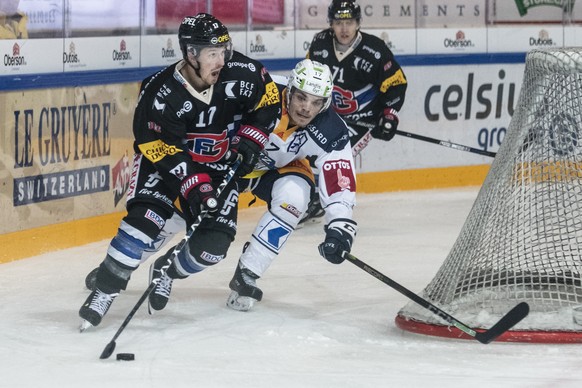 Fribourgs Andrew Miller, links, gegen Zugs Thomas Thiry, links, im Eishockey Meisterschaftsspiel der National League zwischen dem HC Fribourg-Gotteron und dem EV Zug, am Dienstag, 25. September 2018,  ...