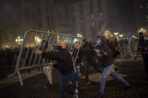 Demonstrators throw metallic fences against police during clashes in downtown Barcelona, Spain, Friday, Oct. 30, 2020. Clashes have erupted in a central Barcelona square between anti-riot police and h ...
