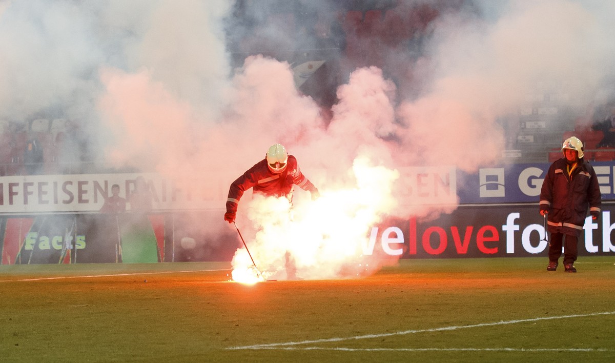 Firefighters remove light flares launching by Grasshopper's supporters, during the Super League soccer match of Swiss Championship between FC Sion and Grasshoppers Club, at the Stade de Tourbillo ...