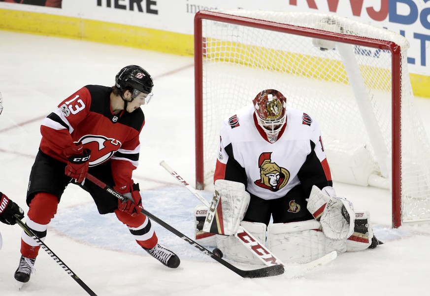 Ottawa Senators goalie Mike Condon (1) blocks a shot by New Jersey Devils center Nico Hischier (13), of Switzerland, during the third period of an NHL hockey game, Friday, Oct. 27, 2017, in Newark, N. ...