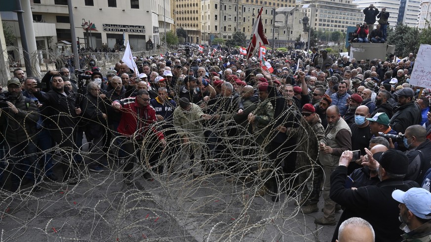 epa10550590 Retired members of Lebanese security try to remove barbed wire during a protest outside the government palace in downtown Beirut, Lebanon, 30 March 2023. Hundreds of retired members of the ...