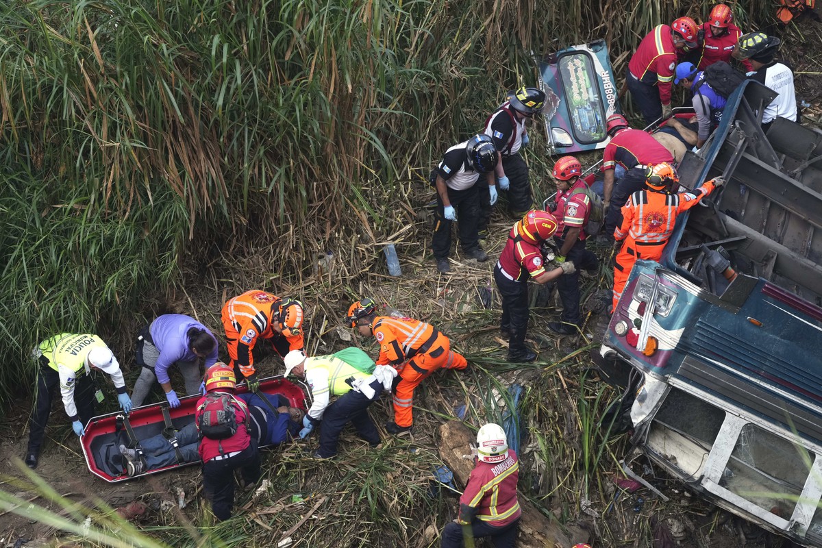 Firefighters work at the scene of a fatal bus crash after it fell from a bridge on the outskirts of Guatemala City, Monday, Feb. 10, 2025. (AP Photo/Moises Castillo)