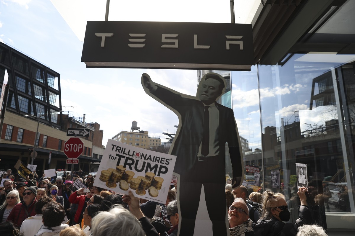 epa11933287 People gather to protest Tesla CEO Elon Musk's involvement with the Trump administration, outside the Tesla Meatpacking District showroom in New York, USA, 01 March 2025. Musk has bee ...