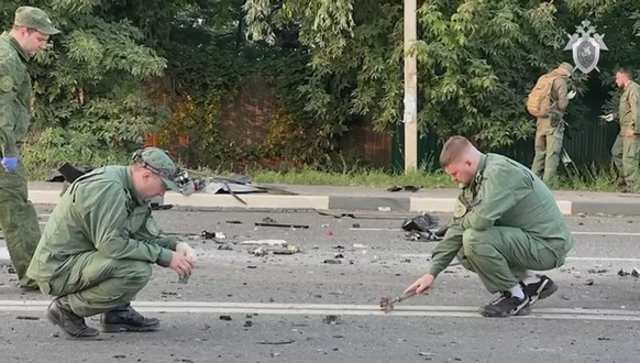 epa10131614 A still image taken from a handout video footage made available 21 August 2022 by the Russian Investigative Committee shows investigators working at the scene of a car explosion on Mozhais ...