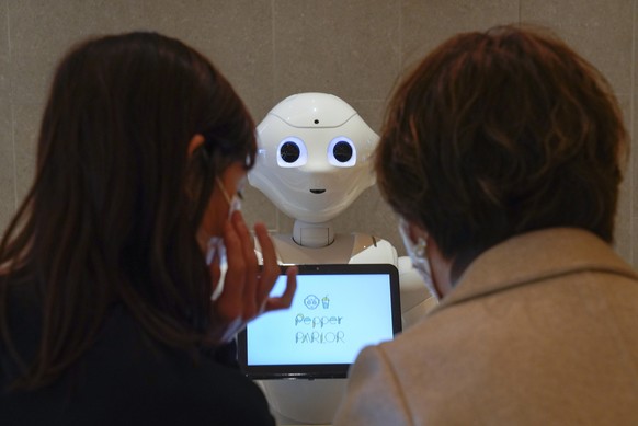 epa08812764 Pepper, a robot developed by SoftBank Robotics Corp., welcomes customers to assist food orders at Pepper PARLOR, where robots are working with human staff, in Tokyo, Japan, 05 November 202 ...